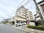落ち着いた色合いの外壁が街並みに調和する、心地よい日常の舞台となる佇まい。