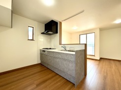 家族との距離が近い対面式キッチンを採用。吊戸棚付きで収納スペースも確保しました。