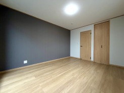 ~寝室~
主寝室は落ち着いたトーンのアクセントクロスとナチュラルな木目が調和する7.9帖のゆとりある広さです。収納も備えた機能的な設計で、心安らぐ静かなひとときを演出する大人のためのプライベート空間です。